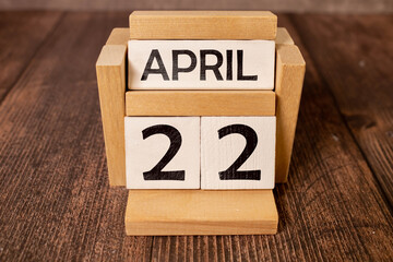 Wooden calendar on wooden desk show the date of April 22 ,