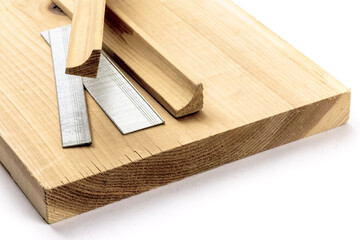A variety of strips of finishing nails or brads in various lengths and pieces of wood trim molding...