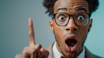 Astonished man pointing with glasses signifies sudden realization or having an idea. Perfect for creative thinking, inspiration, education, innovation articles, presentations, or brainstorming visuals - obrazy, fototapety, plakaty