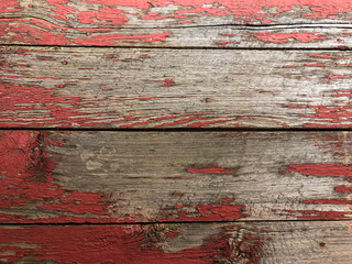Old rustic wooden boards background with red peeling paint