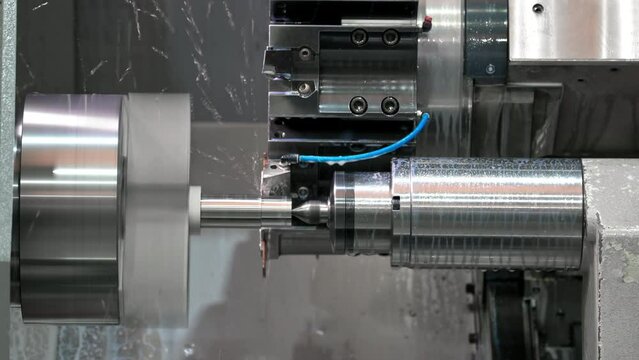 The CNC lathe machine forming cutting the metal shaft parts. hi-technology metal working by CNC turning machine . High quality 4k footage