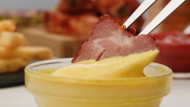Pouring grill bbq piece of pork kebab yellow creamy cheese sauce close-up. Eat beef, chicken or pork meat with Peruvian sauce. Fast and junk food concept.