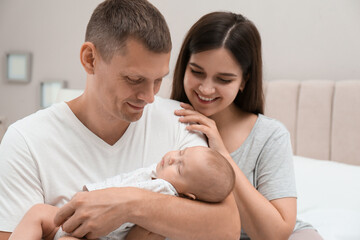 Fototapeta premium Happy family with their cute sleeping baby at home