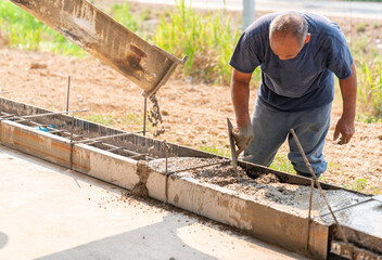 Using trowel worker plasters wet concrete cement wheel stop after