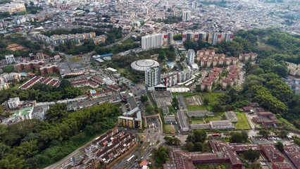 Obraz premium Aerial view of the city of Armenia, Quindío, Colombia. Buildings in the city of Armenia between trees and the green mountains in the background