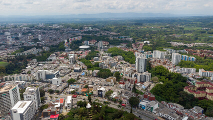 Aerial view of the city of Armenia, Quindío, Colombia. Buildings in the city of Armenia between trees and the green mountains in the background