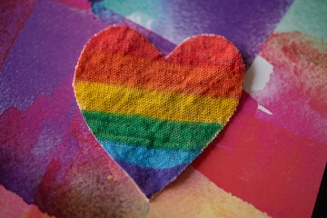 corazón detela pintado de bandera de orgullo gay,  de arcoiris con fondo colorido
