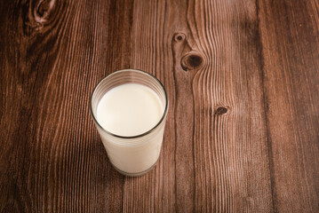 Milk glass isolated on wooden background. Copy space.