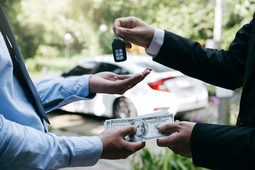 Businessman holding money and receive key from customer, loan car, insurance, sale, buying car and...