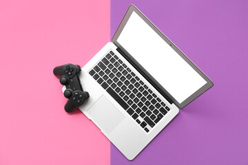 Modern laptop and joystick on color background © Pixel-Shot
