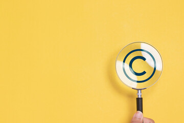 Copyright or patent concept. Magnifying glass focus to copyright symbol for author rights and...