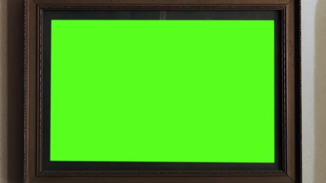 Old Wooden Frame with Green Background Close Up. Zoom Out. You can replace green screen with the footage or picture you want with “Keying” effect in After Effects (check out tutorials on YouTube). 4K.
