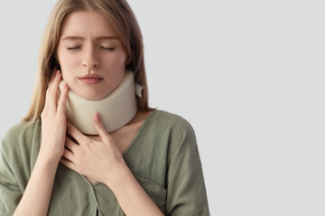 Injured young woman with cervical collar after accident on light background, closeup