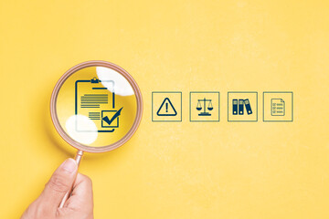 Compliance in business concept. Magnifying glass focus to compliance icon on yellow background, ensuring the enforcement of laws, regulations, and standards. Stay in line with business policies. - obrazy, fototapety, plakaty