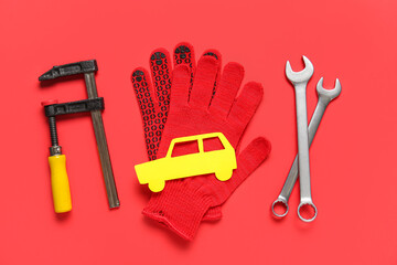 Set of mechanic tools, gloves and toy car on red background. Mechanic concept
