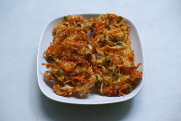 A plate of bakwan sayur or vegetable fritter in white background 