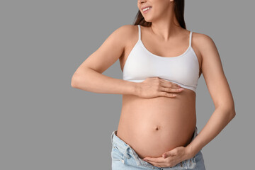 Young pregnant woman on light background, closeup