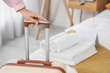 Female tourist with suitcase in hotel room, closeup