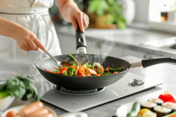 Chef cooking vegetables in a frying pan - A chef's hands stir-frying colorful vegetables in a pan over a modern stove in a bright kitchen setting