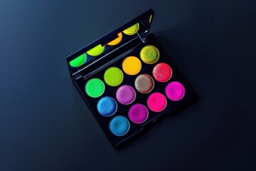 Colorful eyeshadow palette on black background. Bright neon shades. Trendy makeup product. Beauty and fashion concept.