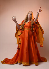 Full length portrait of plus sized woman blonde hair, wearing historical medieval fantasy gown, golden crown of royal queen. Standing pose holding crystal seer orb, isolated studio background.
