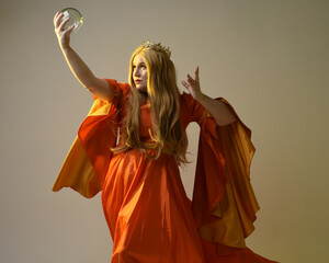 close up portrait of plus sized blonde woman, wearing historical medieval fantasy gown, golden crown of royal queen. gestural hands posing holding magic crystal seer orb, isolated studio background.