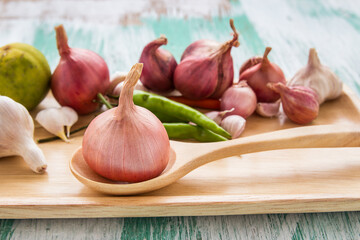 Fresh organic red onion garlic and lemon on wooden background