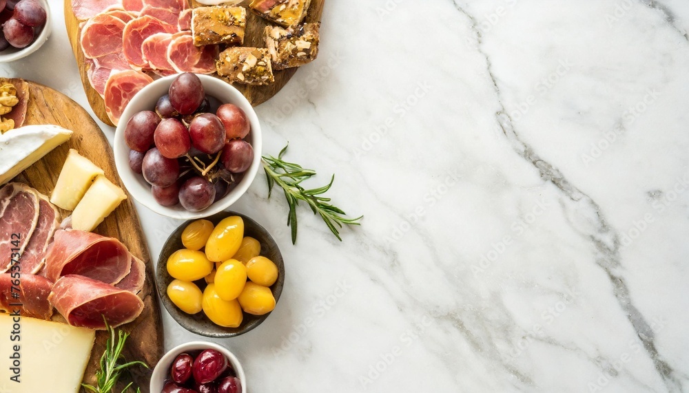 Canvas Prints variety of charcuterie cheeses meats and appetizers overhead view side border on a white marble background with copy space