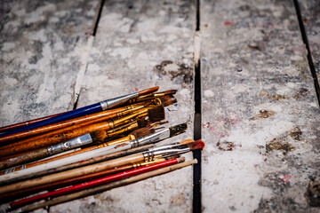 colored brushes stacked on a craftsman's table - canvas concept