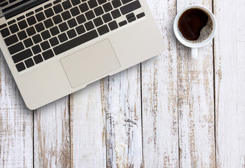 Office table with laptop computer and coffee cup.