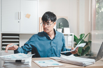 manager, businessperson, consultant, document, executive, job, occupation, paperwork, report, working. A man is sitting at a desk with a pile of papers. He is frustrated by the amount of work.