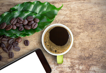 Cup of coffee and smart phone with coffee beans