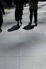 街を歩く人々と人影。東京丸の内のランチタイム、モノクロームで撮影。