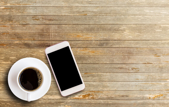 Smart phone with blank screen area and coffee cup