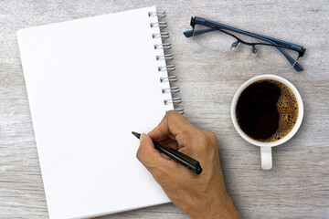 Blank notebook with hand and coffee cup