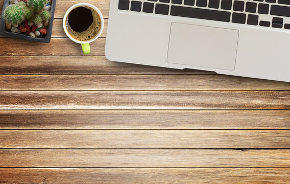 Top view with laptop computer and cup of coffee on wood table background