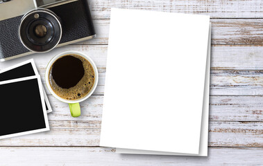 White paper and cup of coffee and camera on wood table background.