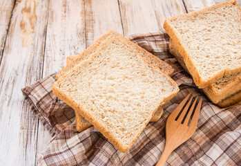 Whole wheat bread on white wooden background