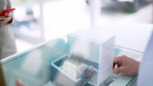 Medical pharmacy and contactless payment concept. Asian woman patient customer using mobile phone scan QR code on counter making online baking payment buying medicine and supplements in drugstore.