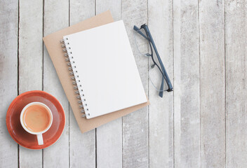 Blank paper notebook on white wood background.