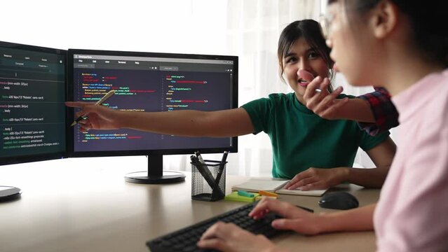 Slow motion back end software developer engineer for computer programming working together on debugging writing computing code, solving complex algorithms display on monitor in office. Burgeoning
