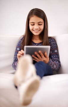 Relax, home or child with tablet for streaming, playing games or watching funny videos on a movie website. Education, online or happy girl with technology to download on app or reading ebook on couch