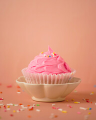 Closeup of a pink cupcake with sprinkles on top