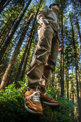 Man Standing on a Fallen Tree in the Middle of a Coniferous Forest