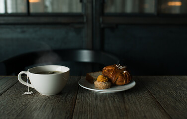 Swedish fika, cakes on a table with a steaming hot cup of herbal tea