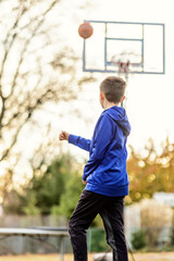 Boy shooting a basketball outdoors