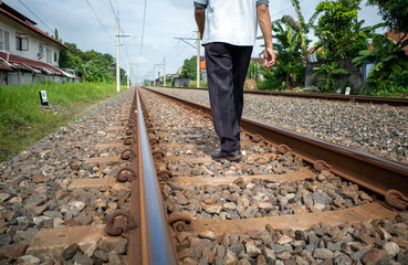 A man walking on railway tracks around settlements in rural areas in Indonesia