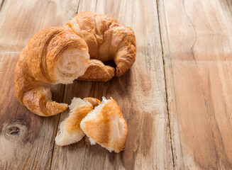 Fresh croissants on old wooden table