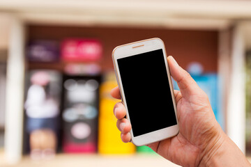 Hand holding smart phone with blur background