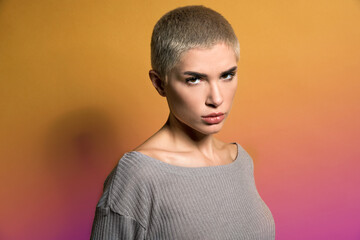 Cool young lady gazing at camera in studio